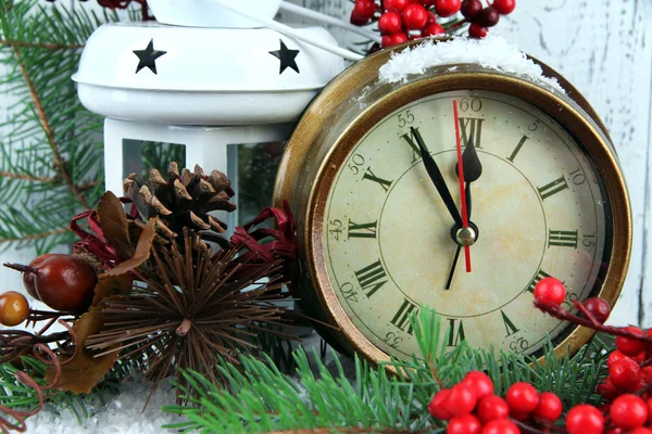 Reloj con ramas de abeto y decoraciones de Navidad en la mesa sobre fondo de madera —  Fotos de Stock