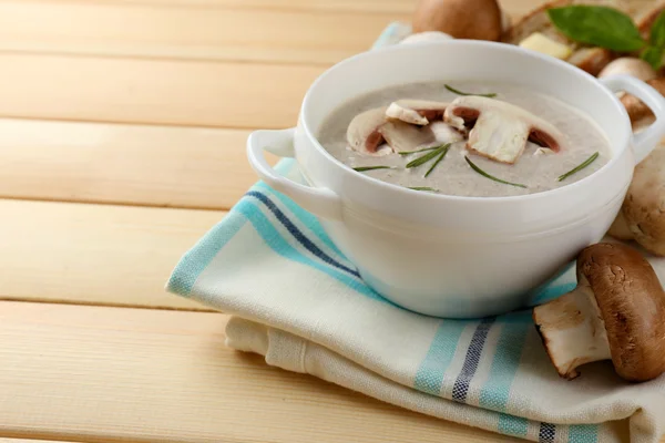 Mushroom soup in pot, on color napkin,  on wooden background — Stock Photo, Image