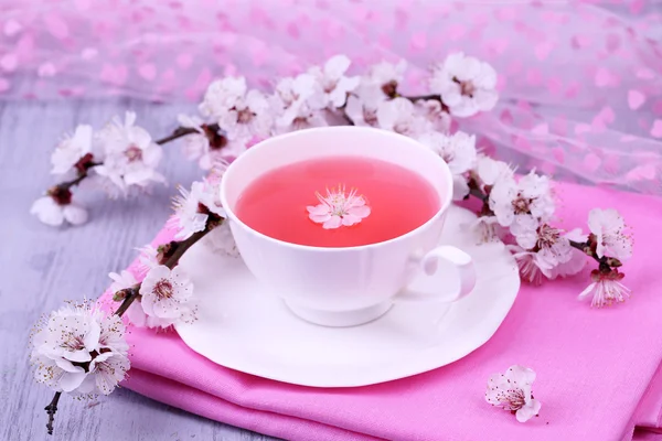 Çiçekli dallar üzerinde ahşap masa yakın çekim güzel kokulu çay — Stok fotoğraf