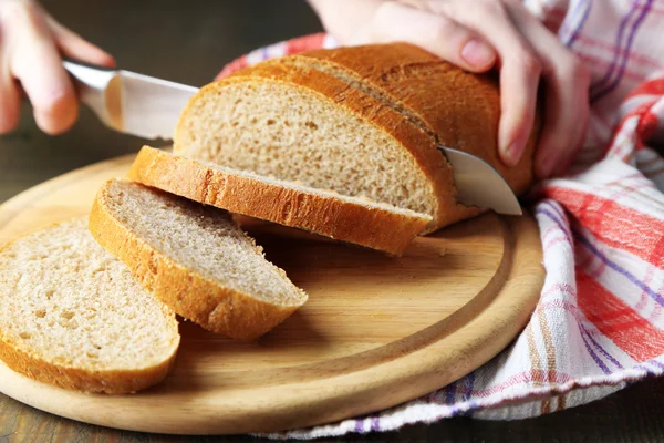 Mãos femininas cortando pão — Fotografia de Stock