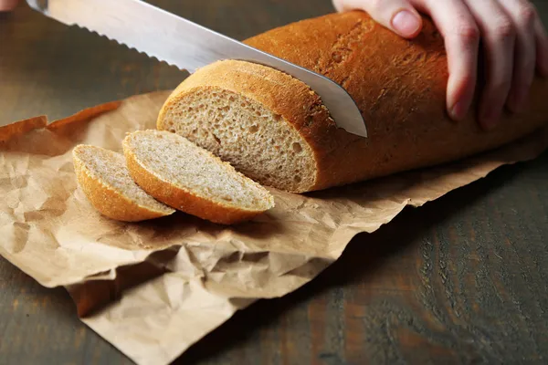 Female hands cutting bread — Stock Photo, Image