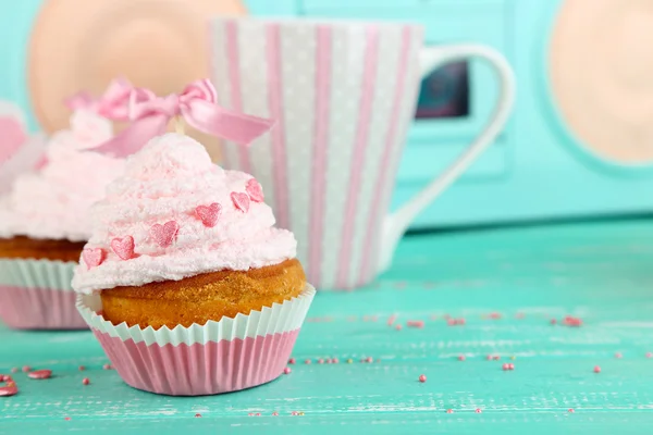 Leckere Tasse Kuchen mit Sahne auf blauem Holztisch — Stockfoto