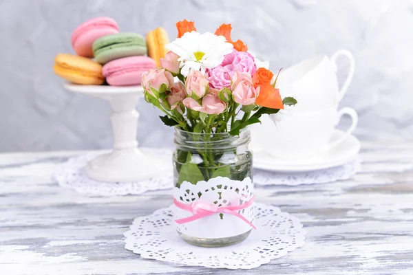 Красивый букет ярких цветов в банке на столе на сером фоне — стоковое фото