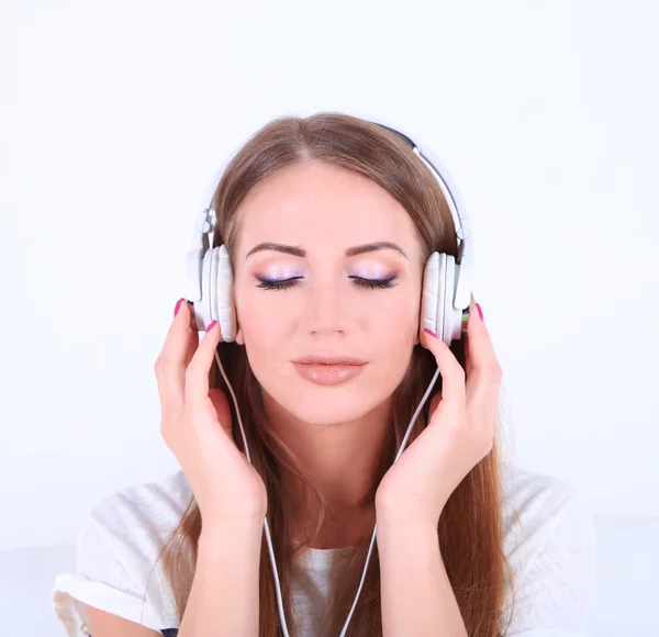 Chica joven escuchar música aislada en blanco — Foto de Stock