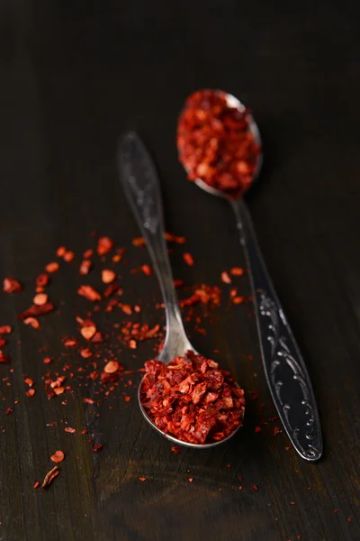 Spice pepper in spoons on wooden background — Stock Photo, Image