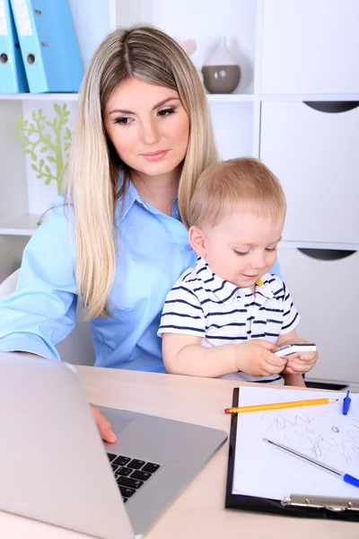 Mujer bonita con bebé trabajando en casa — Foto de Stock