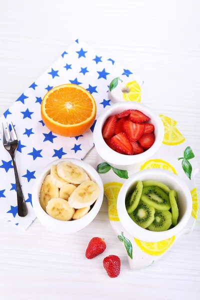 Vários frutos cortados em tigelas na mesa close-up — Fotografia de Stock