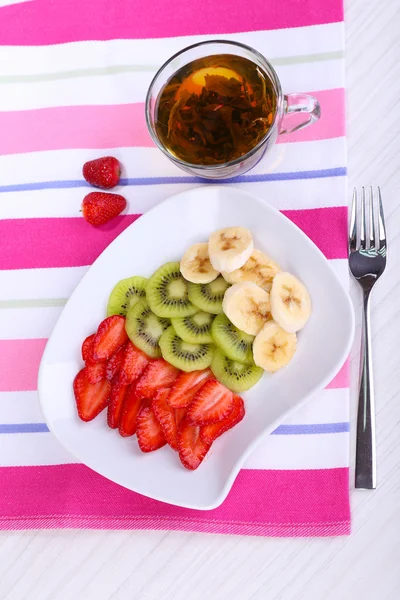 Various sliced fruits on plate on table close-up — Stock Photo, Image