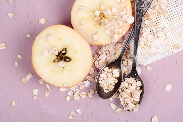 Apple with oatmeal and vintage spoons — Stock Photo, Image