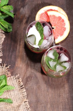 ahşap masa arka planda lezzetli kokteyl ile taze greyfurt ve nane yaprakları