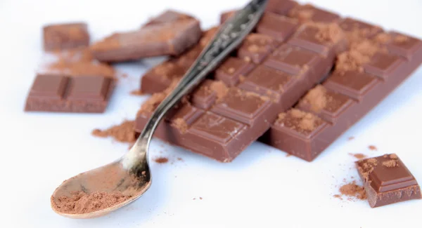 Cocoa powder and dark chocolate isolated on white — Stock Photo, Image