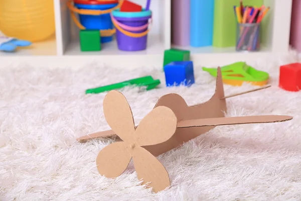 Paper airplane toy in room on the carpet — Stock Photo, Image