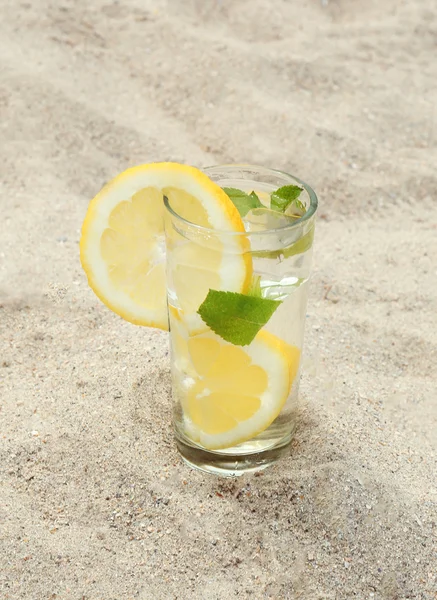 Bebida fria com gelo, hortelã e limão na praia — Fotografia de Stock