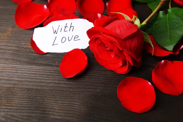 Hermosos pétalos de rosas rojas sobre fondo de madera — Foto de Stock