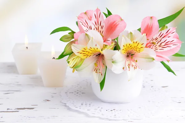 Alstremeria kwiaty w wazonie na stole na jasnym tle — Zdjęcie stockowe