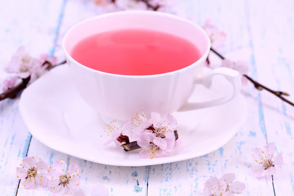 Fragrant tea with flowering branches on wooden table close-up — Stock Photo, Image