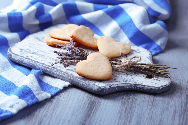 Soubory cookie levandule na prkénko, na barevný ubrousek pozadí — Stock fotografie