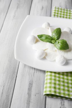 lezzetli mozzarella peyniri Fesleğenli ahşap zemin üzerinde plaka üzerinde