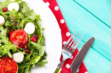 roka, domates, peynir mozzarella toplar ve plaka renk ahşap zemin üzerine susam ile yapılan yeşil salata