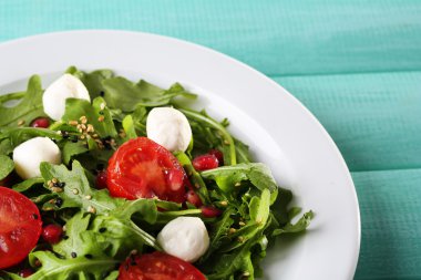 roka, domates, peynir mozzarella toplar ve plaka renk ahşap zemin üzerine susam ile yapılan yeşil salata