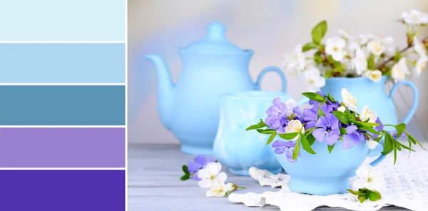 Beautiful spring flowers in cups on wooden table. Color palette with complimentary swatches
