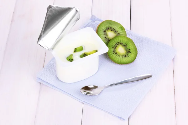 Yogurt con kiwi en servilleta sobre fondo de madera — Foto de Stock