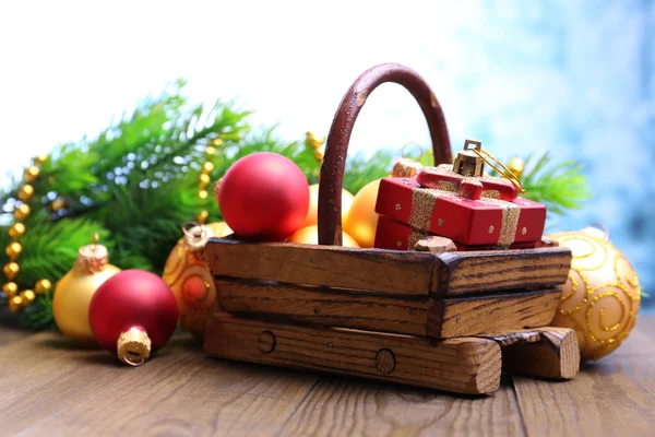 Složení s vánoční ozdoby v košíku, jedle na dřevěný stůl, na světlé pozadí — Stock fotografie