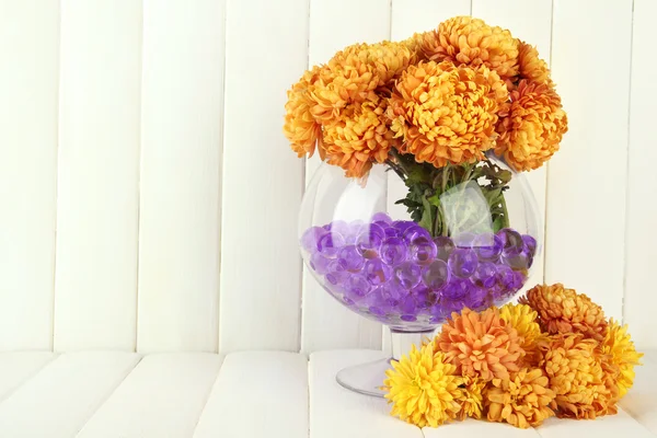 Mooie bloemen in vaas met hydrogel op tafel op houten achtergrond — Stockfoto