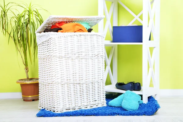 充分的洗衣篮，在家庭内部的背景上的木地板上 — 图库照片
