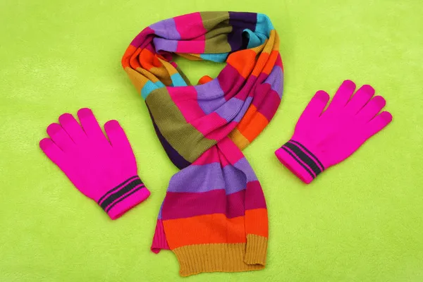 Winter sjaal en handschoenen, op een achtergrond met kleur — Stockfoto