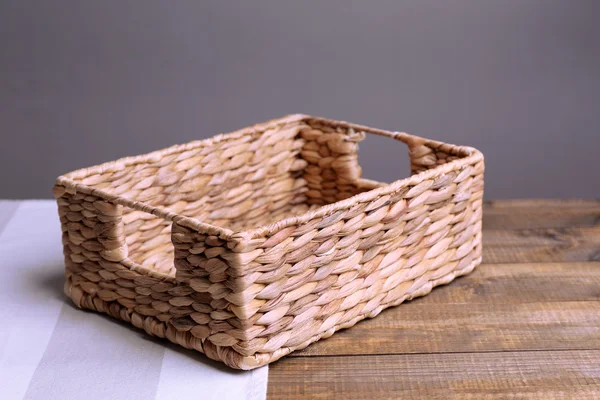 Порожній плетений кошик на дерев'яному столі, на темному тлі — стокове фото
