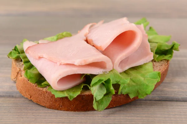 Heerlijke sandwich met sla en ham op tabel close-up — Stockfoto
