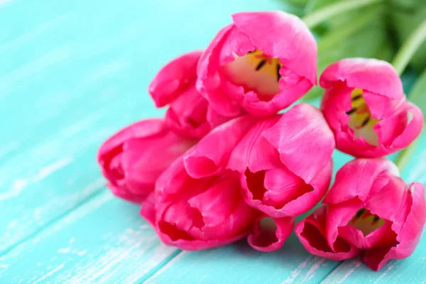 Bei tulipani su sfondo di legno a colori — Foto Stock