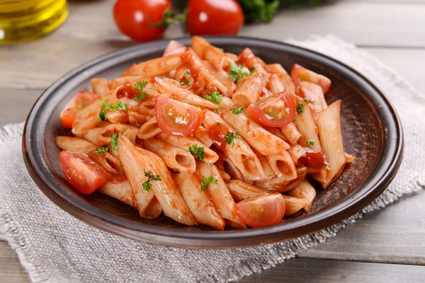 Pasta met tomatensaus op plaat op tabel close-up — Stockfoto