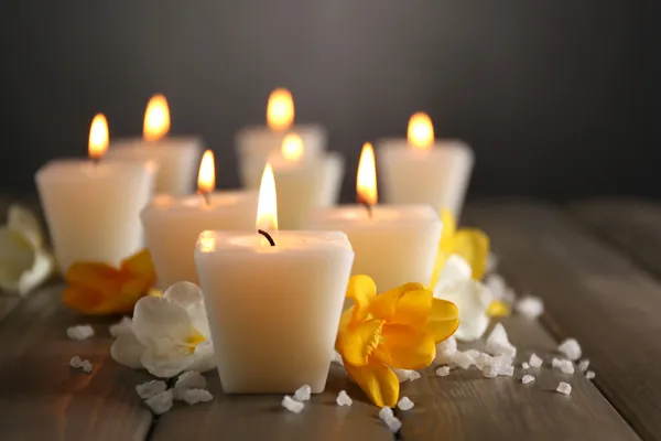 Hermosas velas con flores sobre fondo de madera — Foto de Stock