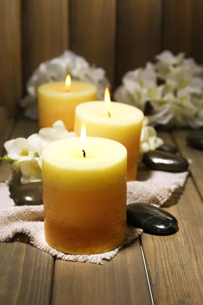 Beautiful candles with flowers on wooden background — Stock Photo, Image