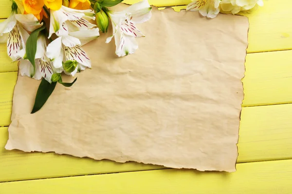 Beautiful Alstroemeria flowers and empty sheet on wooden table — Stock Photo, Image