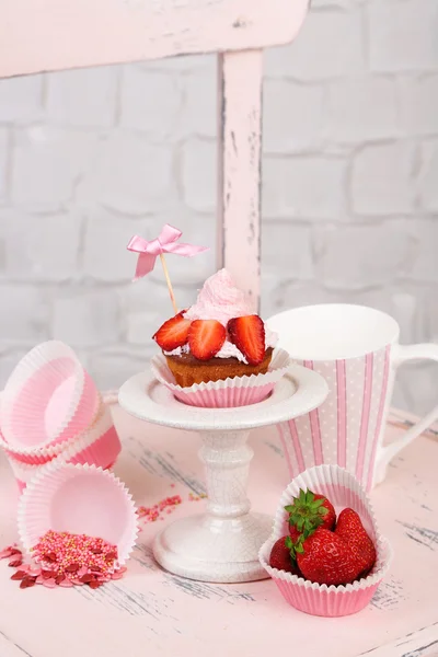 木製の椅子の上のクリームのおいしいカップ ケーキ — ストック写真