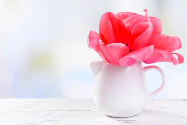 Vackra tulpaner i hink i vas på bordet på ljus bakgrund — Stockfoto
