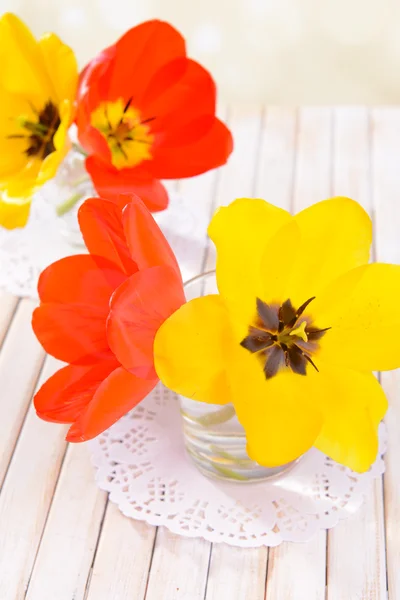 Bei tulipani in secchio in vaso sul tavolo su sfondo chiaro — Foto Stock