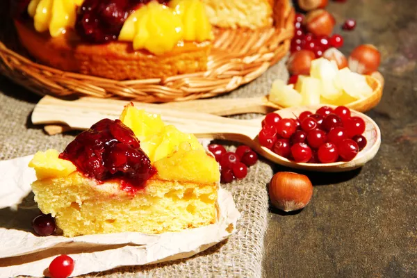 Torta caseira frutada saborosa com bagas e nozes, em mesa de madeira cinza — Fotografia de Stock