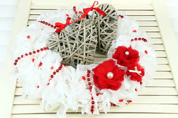 Декоративный венок с плетеными сердцами на деревянном фоне — стоковое фото