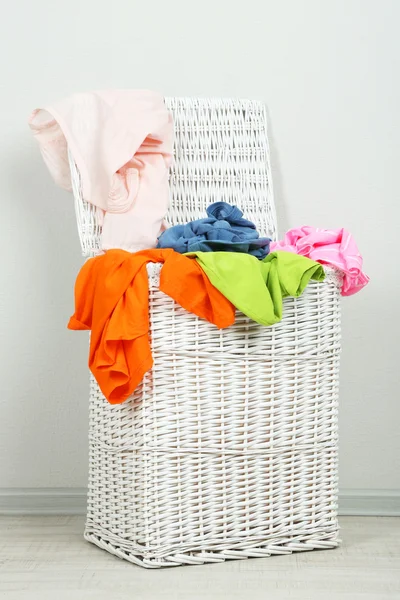 Full laundry basket on gray background — Stock Photo, Image