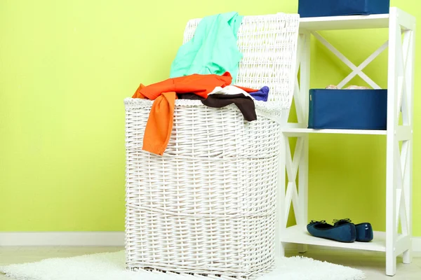 Full laundry basket  on wooden floor on  home interior background — Stock Photo, Image