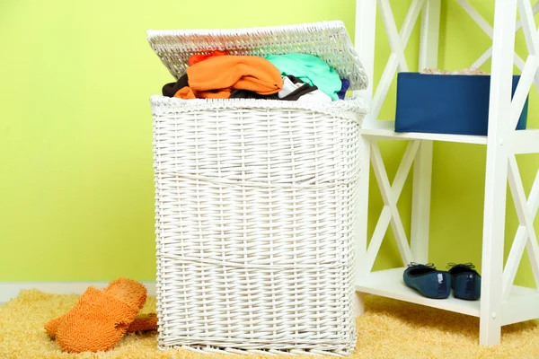 Fuld vasketøjskurv på trægulv på hjem indvendig baggrund - Stock-foto