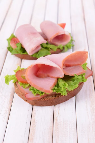 Läckra smörgåsar med sallad och skinka på bordet närbild — Stockfoto