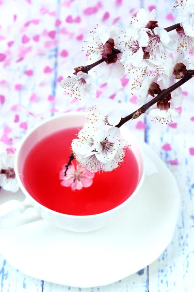 Fragrant tea with flowering branches on wooden table close-up — Stock Photo, Image