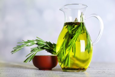 uçucu yağ üzerinde açık renkli cam sürahi içinde rosemary ile