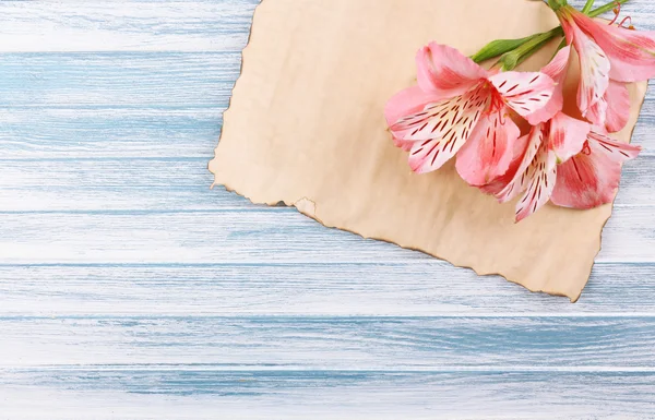 Vackra alstroemeria blommor och tomma ark på träbord — Stockfoto