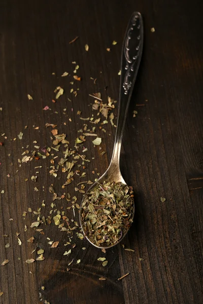 Spice greens in spoon on wooden background — Stock Photo, Image